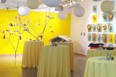 The ArtStarts Gallery decorated with white lanterns and a series of tables with yellow table cloth