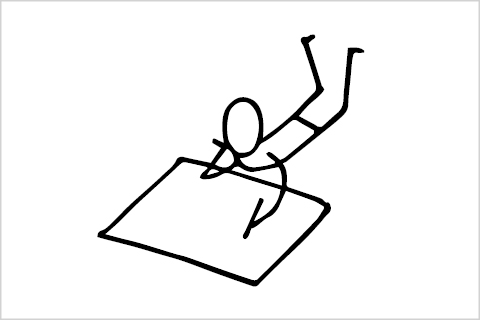 A stick figure laying on the ground drawing on a big piece of paper